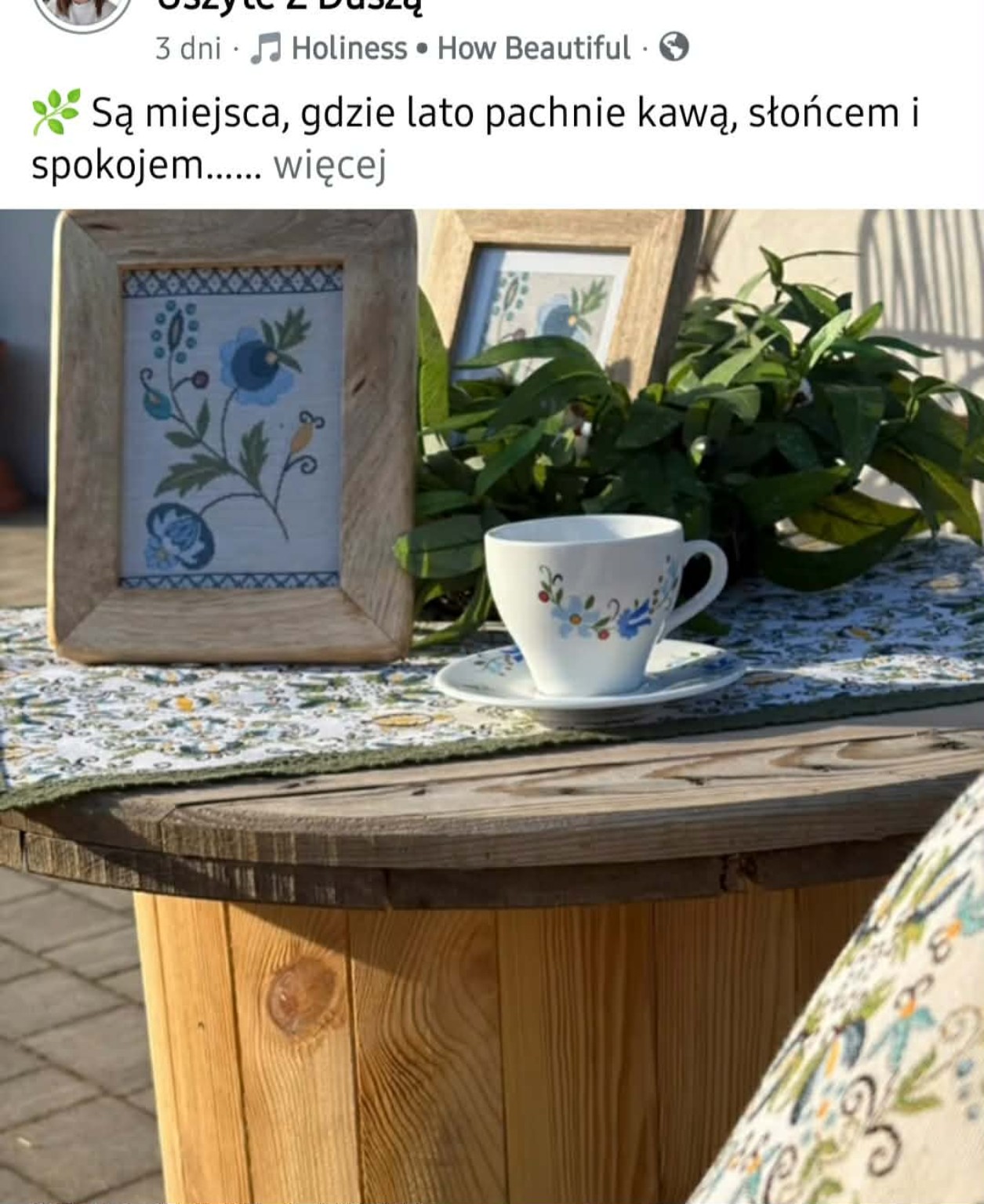 Porcelanowa filiżanka w kaszubskie wzory obok obrazu z haftem